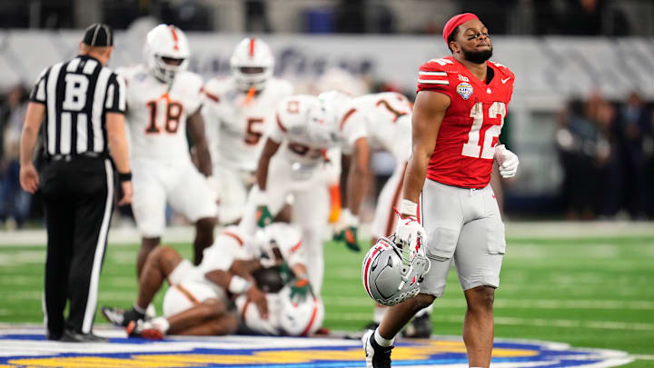 Ohio State Buckeyes running back CJ Donaldson Jr. (12) runs off the field after Miami Hurricanes defensive back Jakobe Thomas (8) sealed the game with an interception in the Cotton Bowl at AT&T Stadium in Arlington, Texas for the College Football Playoff quarterfinal game on Dec. 31, 2025. Ohio State lost 24-14.