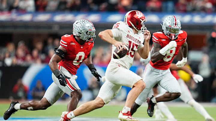 Indiana Hoosiers quarterback Fernando Mendoza (15) scrambles past Ohio State Buckeyes linebacker Sonny Styles (0) and linebacker Arvell Reese (8) during the Big Ten Conference championship game at Lucas Oil Stadium in Indianapolis on Dec. 6, 2025. Ohio State lost 13-10.