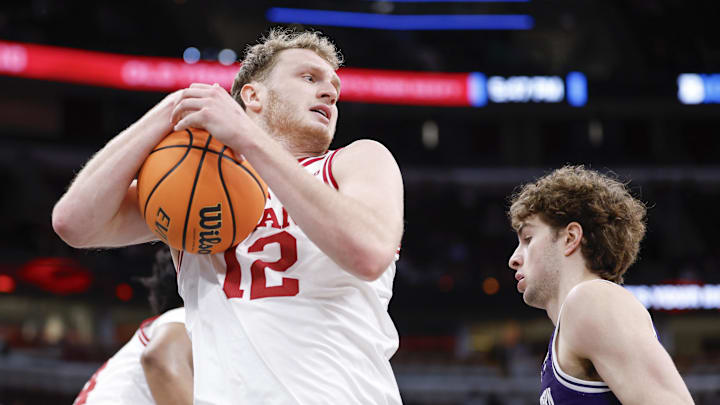 Mar 11, 2026; Chicago, IL, USA; Indiana Hoosiers forward Tucker Devries (12) grabs a rebound against the Northwestern Wildcats during the first half at United Center. Mandatory Credit: Kamil Krzaczynski-Imagn Images