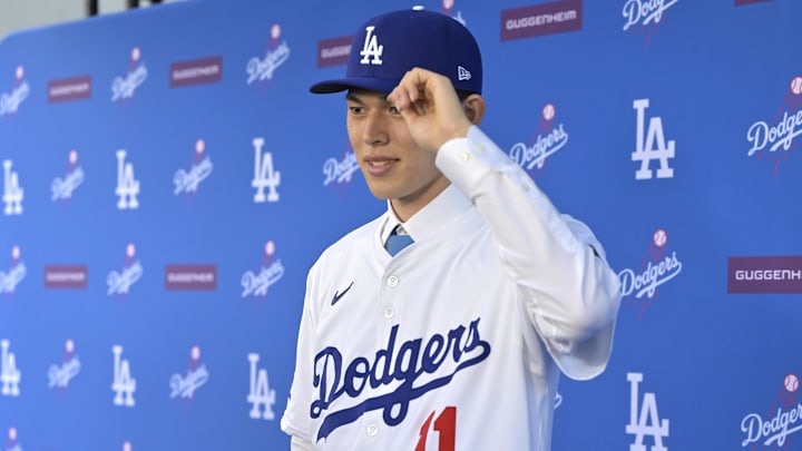Los Angeles Dodgers pitcher Roki Sasaki (11) is photographed by media during an introductory press conference at Dodger Stadium.