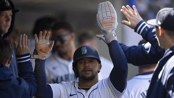 Seattle Mariners left fielder Jonatan Clase (5) is congratulated by teammates in the dugout after scoring a run during the seventh inning against the Cincinnati Reds at T-Mobile Park on April 17.