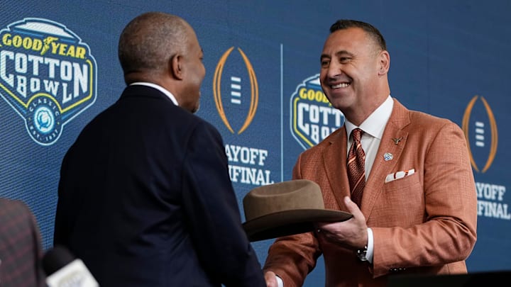 Cotton Bowl chairman Kelvin Walker presents Texas Longhorns head coach Steve Sarkisian with a cowboy hat during a press conference at AT&T Stadium prior to the College Football Playoff semifinal at the Cotton Bowl Classic in Arlington, Texas on Jan. 9, 2025.