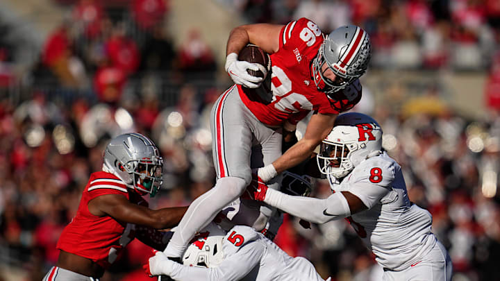 Ohio State Buckeyes tight end Max Klare (86) leaps over Rutgers Scarlet Knights linebacker Dariel Djabome (8) and defensive back Kaj Sanders (5) during the NCAA football game at Ohio Stadium in Columbus on Nov. 22, 2025. Ohio State won 42-9.