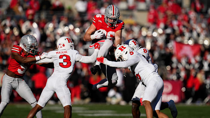 Ohio State Buckeyes tight end Max Klare (86) hurdles Rutgers Scarlet Knights defensive back Bo Mascoe (3), defensive back Kaj Sanders (5) and linebacker Dariel Djabome (8) during the second half of the NCAA football game at Ohio Stadium in Columbus on Nov. 22, 2025. Ohio State won 42-9.