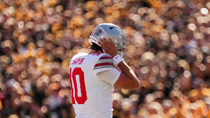 Ohio State Buckeyes quarterback Julian Sayin (10) covers his ears to hear the play call during the NCAA football game against the Iowa Hawkeyes at Kinnick Stadium in Iowa City on Oct. 3, 2026.