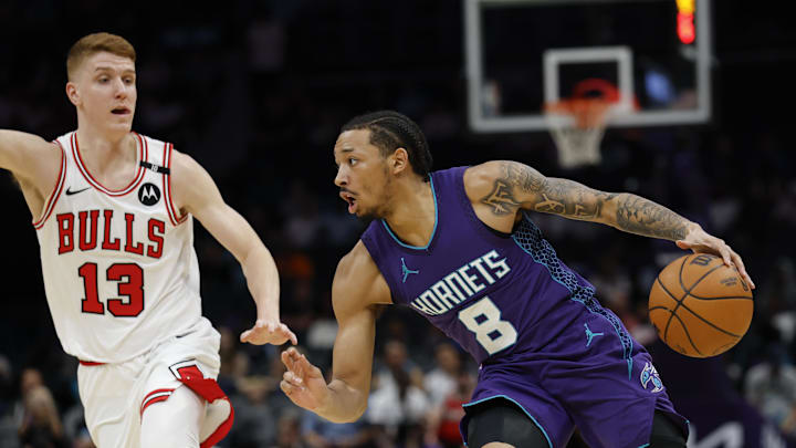 Apr 6, 2025; Charlotte, North Carolina, USA; Charlotte Hornets guard Nick Smith Jr. (8) drives against Chicago Bulls guard Kevin Huerter (13) during the first quarter at Spectrum Center. Mandatory Credit: Nell Redmond-Imagn Images