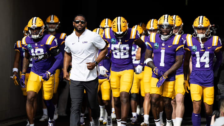 Jan 1, 2024; Tampa, FL, USA; LSU Tigers wide receivers coach Cortez Hankton, tight end Ka'Morreun Pimpton (88), and wide receiver Aaron Anderson (1) run onto the field before the game against the Wisconsin Badgers at Raymond James Stadium. Mandatory Credit: Matt Pendleton-Imagn Images