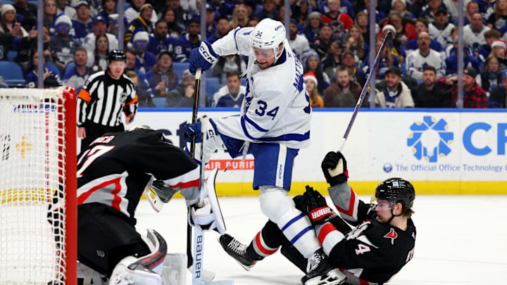Dec 20, 2024; Buffalo, New York, USA;  Buffalo Sabres goaltender James Reimer (47) makes a save on Toronto Maple Leafs center Auston Matthews (34) as Buffalo Sabres defenseman Bowen Byram (4) falls down trying to defend during the third period at KeyBank Center. Mandatory Credit: Timothy T. Ludwig-Imagn Images