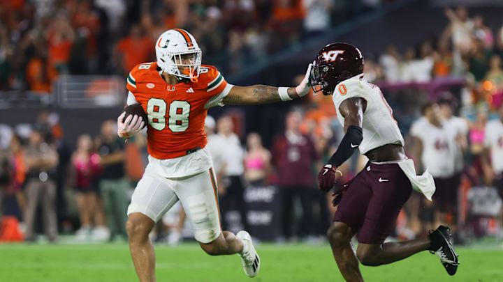 Sep 27, 2024; Miami Gardens, Florida, USA; Miami Hurricanes tight end Riley Williams (88) stiff arms Virginia Tech Hokies linebacker Keli Lawson (0) during the fourth quarter at Hard Rock Stadium. Mandatory Credit: Sam Navarro-Imagn Images