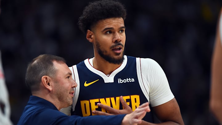Oct 25, 2025; Denver, Colorado, USA; Denver Nuggets forward Cameron Johnson (23) talks with head coach David Adelman during the first half against the Phoenix Suns at Ball Arena.