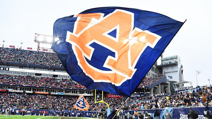 Dec 30, 2023; Nashville, TN, USA; An Auburn Tigers cheerleader waives a flag in the end zone after a touchdown during the first half against the Maryland Terrapins at Nissan Stadium. Mandatory Credit: Christopher Hanewinckel-Imagn Images