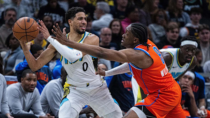 Dec 26, 2024; Indianapolis, Indiana, USA; Indiana Pacers guard Tyrese Haliburton (0) looks to pass the ball while Oklahoma City Thunder forward Jalen Williams (8) defends in the second half at Gainbridge Fieldhouse. Mandatory Credit: Trevor Ruszkowski-Imagn Images