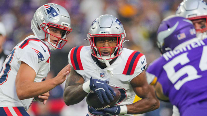 Aug 16, 2025; Minneapolis, Minnesota, USA; New England Patriots running back TreVeyon Henderson (32) runs with the ball against the Minnesota Vikings in the first quarter at U.S. Bank Stadium. Mandatory Credit: Brad Rempel-Imagn Images