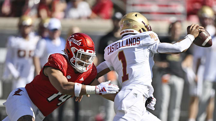 Sep 23, 2023; Louisville, Kentucky, USA;  Louisville Cardinals defensive lineman Stephen Herron (14) attempts to sack Boston College Eagles quarterback Thomas Castellanos (1) during the first quarter at L&N Federal Credit Union Stadium. Mandatory Credit: Jamie Rhodes-Imagn Images