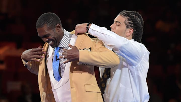 Former NFL star receiver Randy Moss receives gold jacket from presenter and son Thaddeus Moss during the Enshrinee's gold jacket dinner at the Canton Civic Center on August 3, 2018. Former NFL star receiver Randy Moss receives gold jacket from presenter and son Thaddeus Moss during the Enshrinee's gold jacket dinner at the Canton Civic Center on August 3, 2018.