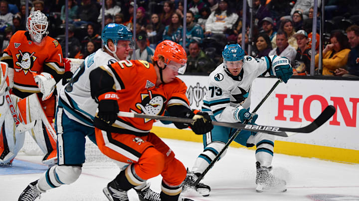 Oct 22, 2024; Anaheim, California, USA; Anaheim Ducks defenseman Jackson LaCombe (2) plays for the puck against San Jose Sharks left wing Fabian Zetterlund (20) and center Tyler Toffoli (73) during the third period at Honda Center. Mandatory Credit: Gary A. Vasquez-Imagn Images