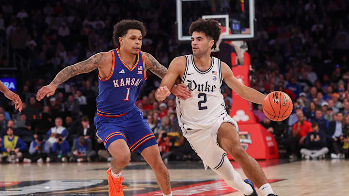 Nov 18, 2025; New York, New York, USA; Duke basketball guard Cayden Boozer (2) dribbles as Kansas Jayhawks guard Jayden Dawson (1) defends during the second half at Madison Square Garden. 