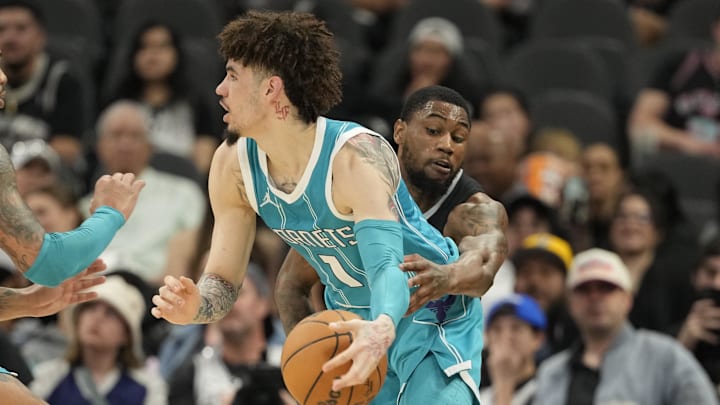 Mar 14, 2025; San Antonio, Texas, USA; San Antonio Spurs guard Malaki Branham (22) reaches in for the ball while defending Charlotte Hornets guard LaMelo Ball (1) during the second half at Frost Bank Center. Mandatory Credit: Scott Wachter-Imagn Images