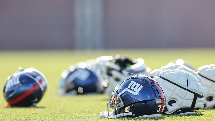 New York Giants helmets rest on the grass field during training camp at the Quest Diagnostics Training Facility.   