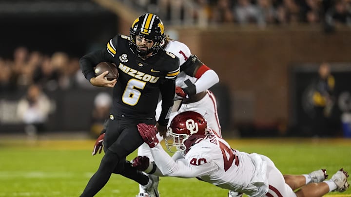 Nov 9, 2024; Columbia, Missouri, USA; Missouri Tigers quarterback Drew Pyne (6) runs the ball against Oklahoma Sooners defensive lineman Ethan Downs (40) and Oklahoma Sooners linebacker Dasan McCullough (1) during the first half at Faurot Field at Memorial Stadium. Mandatory Credit: Jay Biggerstaff-Imagn Images Nov 9, 2024; Columbia, Missouri, USA; Missouri Tigers quarterback Drew Pyne (6) runs the ball against Oklahoma Sooners defensive lineman Ethan Downs (40) and Oklahoma Sooners linebacker Dasan McCullough (1) during the first half at Faurot Field at Memorial Stadium. Mandatory Credit: Jay Biggerstaff-Imagn Images