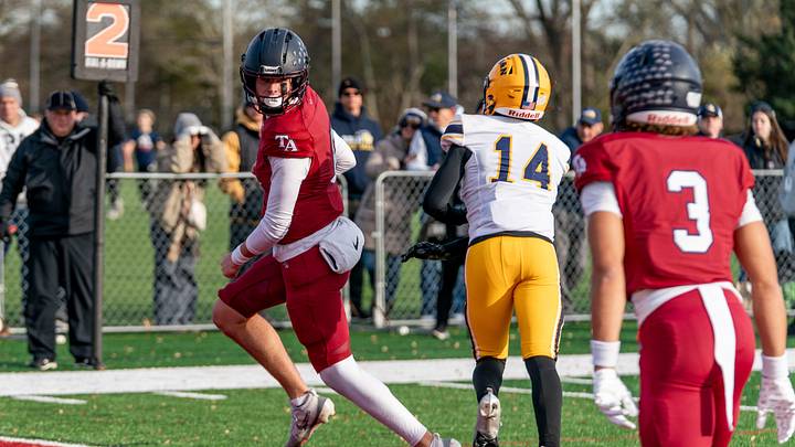 Tabor Academy's quarterback Peter Bourque looks back as he slips into the end zone.