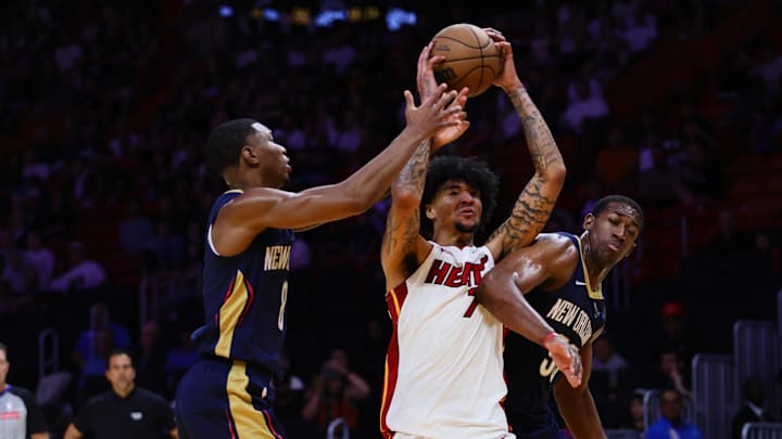 Oct 13, 2024; Miami, Florida, USA; Miami Heat center Kel'el Ware (7) battles for possession against New Orleans Pelicans forward Jamal Cain (8) and center Trey Jemison (55) during the fourth quarter at Kaseya Center. 