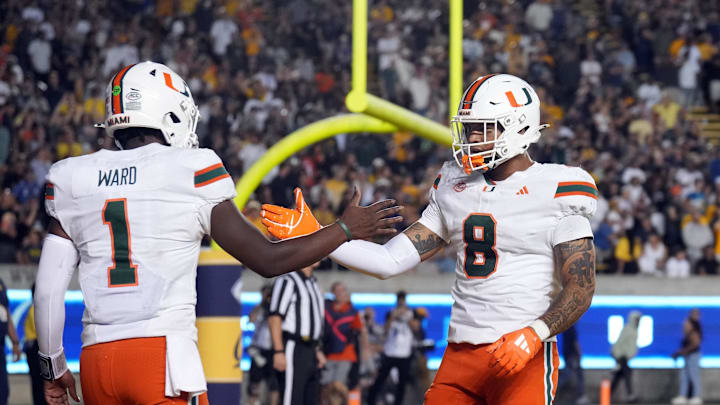 Oct 5, 2024; Berkeley, California, USA; Miami Hurricanes quarterback Cam Ward (1) is congratulated by tight end Elijah Arroyo (8) after scoring a touchdown against the California Golden Bears during the fourth quarter at California Memorial Stadium. Mandatory Credit: Darren Yamashita-Imagn Images