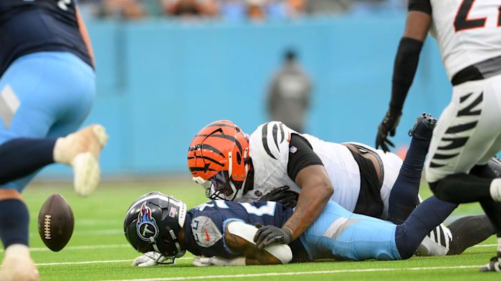 Dec 15, 2024; Nashville, Tennessee, USA;  Cincinnati Bengals linebacker Germaine Pratt (57) and Tennessee Titans running back Tony Pollard (20) dive for the loose ball during the second half at Nissan Stadium. Mandatory Credit: Steve Roberts-Imagn Images