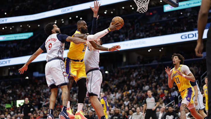 Jan 30, 2025; Washington, District of Columbia, USA; Los Angeles Lakers forward LeBron James (23) leaps to pass the ball to Lakers center Jaxson Hayes (11) as Washington Wizards forward Justin Champagnie (9) and Wizards center Jonas Valanciunas (17) defend in the second quarter at Capital One Arena. Mandatory Credit: Geoff Burke-Imagn Images