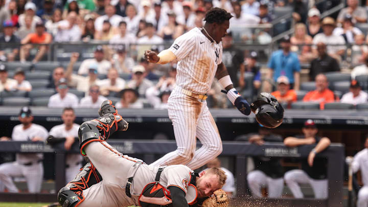 Jun 22, 2025; Bronx, New York, USA; New York Yankees second baseman Jazz Chisholm Jr. (13) collides with Baltimore Orioles catcher Maverick Handley (98) at home plate during the second inning at Yankee Stadium. Mandatory Credit: Vincent Carchietta-Imagn Images