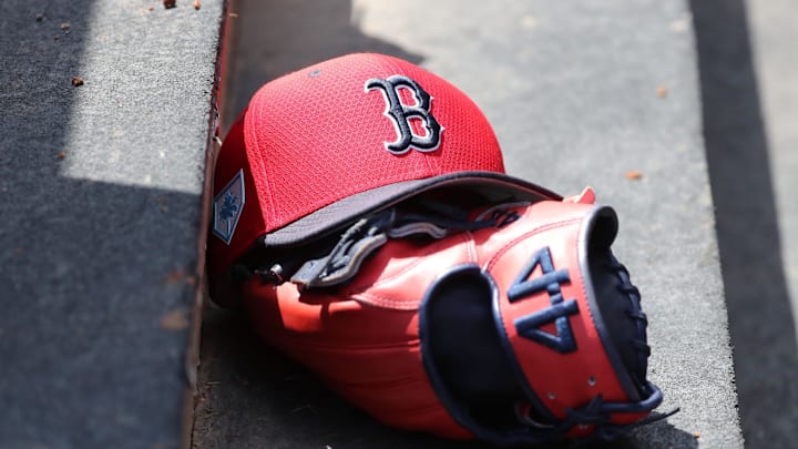 Boston Red Sox hat and glove lay in the dugout  at George M. Steinbrenner Field in 2019.