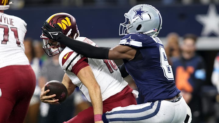 Dallas Cowboys safety Donovan Wilson tackles Washington Commanders quarterback Marcus Mariota.