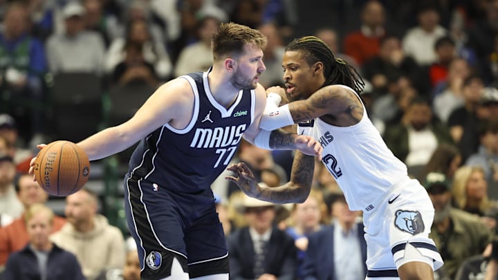 Dec 3, 2024; Dallas, Texas, USA;  Dallas Mavericks guard Luka Doncic (77) controls the ball as Memphis Grizzlies guard Ja Morant (12) defends  during the second half at American Airlines Center. Mandatory Credit: Kevin Jairaj-Imagn Images