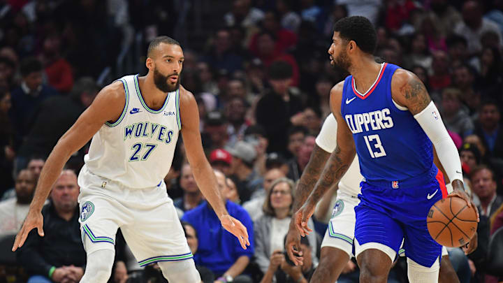 Los Angeles Clippers forward Paul George (13) controls the ball against Minnesota Timberwolves center Rudy Gobert (27) during the first half at Crypto.com Arena in Los Angeles on March 12, 2024.