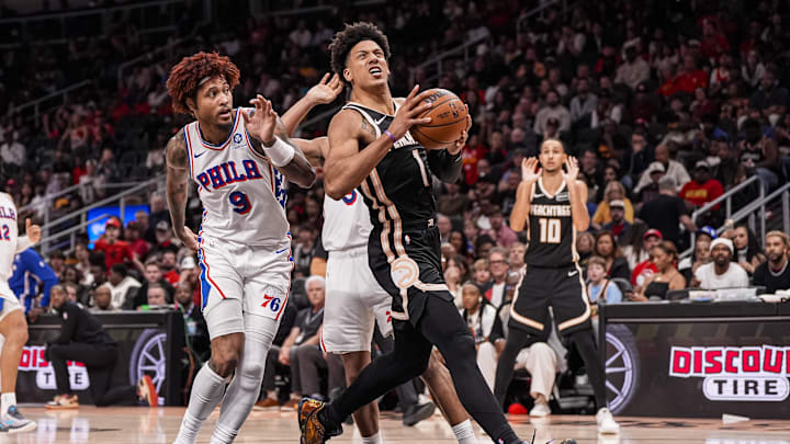 Mar 7, 2026; Atlanta, Georgia, USA; Atlanta Hawks forward Jalen Johnson (1) drives the lane past Philadelphia 76ers forward/guard Kelly Oubre Jr. (9) during the second half at State Farm Arena. Mandatory Credit: Dale Zanine-Imagn Images
