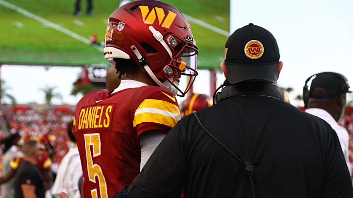 Washington Commanders quarterback Jayden Daniels talks with head coach Dan Quinn 