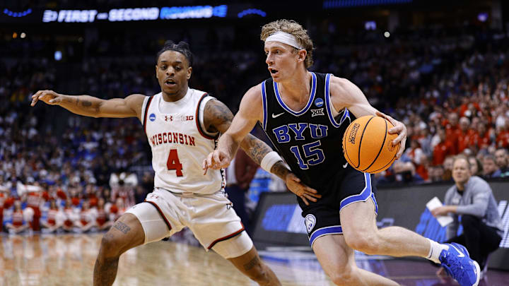 Mar 22, 2025; Denver, CO, USA; Brigham Young Cougars forward Richie Saunders (15) dribbles the ball past Wisconsin Badgers guard Kamari McGee (4) during the second half in the second round of the NCAA Tournament  at Ball Arena. Mandatory Credit: Isaiah J. Downing-Imagn Images