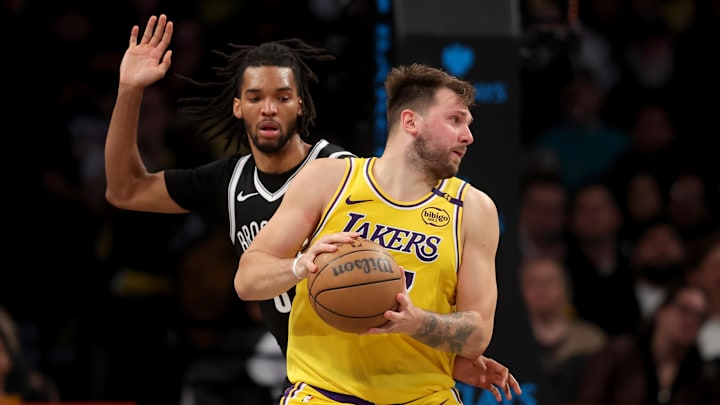 Mar 10, 2025; Brooklyn, New York, USA; Los Angeles Lakers guard Luka Doncic (77) spins around Brooklyn Nets forward Ziaire Williams (8) during the fourth quarter at Barclays Center. Mandatory Credit: Brad Penner-Imagn Images