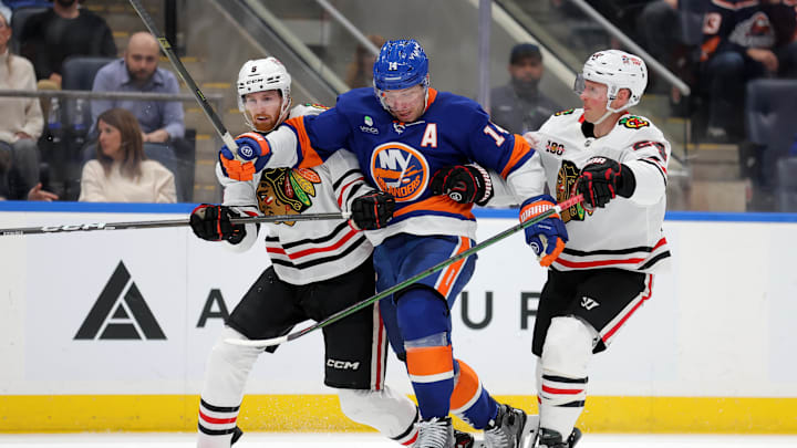 Mar 24, 2026; Elmont, New York, USA; New York Islanders center Bo Horvat (14) skates against Chicago Blackhawks defenseman Sam Rinzel (6) and center Sam Lafferty (24) during the third period at UBS Arena. Mandatory Credit: Brad Penner-Imagn Images