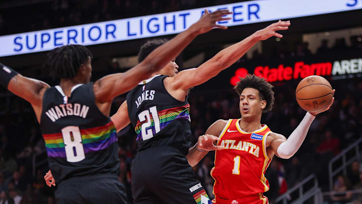 Dec 5, 2025; Atlanta, Georgia, USA; Atlanta Hawks forward Jalen Johnson (1) passes around Denver Nuggets guard Peyton Watson (8) and forward Spencer Jones (21) in the second quarter at State Farm Arena. Mandatory Credit: Brett Davis-Imagn Images

