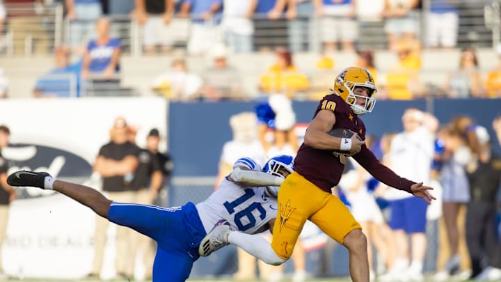 Nov 23, 2024; Tempe, Arizona, USA; Arizona State Sun Devils quarterback Sam Leavitt (10) against diving Brigham Young Cougars linebacker Isaiah Glasker (16) at Mountain America Stadium. Mandatory Credit: Mark J. Rebilas-Imagn Images
