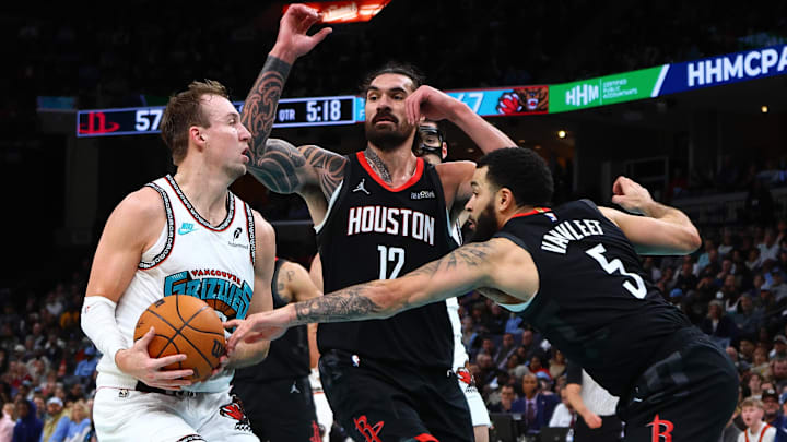 Jan 30, 2025; Memphis, Tennessee, USA; Memphis Grizzlies guard Luke Kennard (10) drives to the basket as Houston Rockets center Steven Adams (12) and guard Fred VanVleet (5) defend during the second quarter at FedExForum. Mandatory Credit: Petre Thomas-Imagn Images