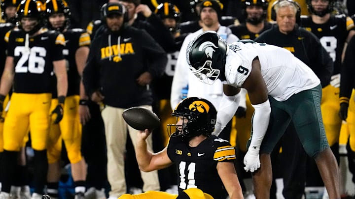 Michigan State Spartans defensive lineman Jalen Thompson (9) reaches down to help up Iowa Hawkeyes quarterback Mark Gronowski (11) Nov. 22, 2025 at Kinnick Stadium in Iowa City, Iowa.