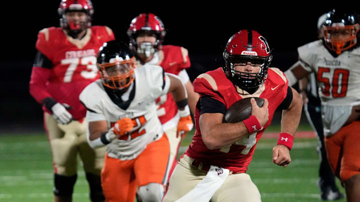 Cardinal Mooney quarterback Devin Mignery (#14) scramble on a quarterback keeper. Cocoa High School defeated Cardinal Mooney Catholic High School 31-21 to win the Class 2A semi-final game Friday night in Sarasota.