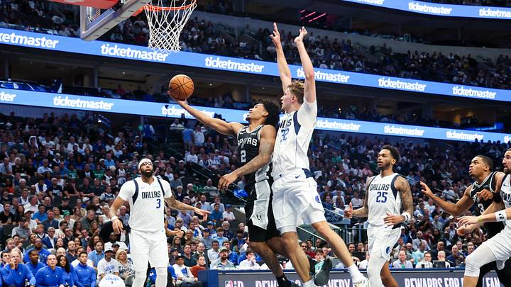 Oct 22, 2025; Dallas, Texas, USA; San Antonio Spurs guard Dylan Harper (2) shoots past Dallas Mavericks forward Cooper Flagg (32) during the second half at American Airlines Center. Oct 22, 2025; Dallas, Texas, USA; San Antonio Spurs guard Dylan Harper (2) shoots past Dallas Mavericks forward Cooper Flagg (32) during the second half at American Airlines Center.