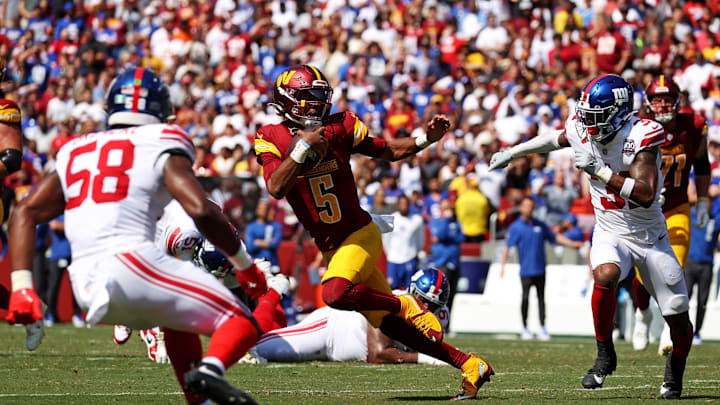 Sep 15, 2024; Landover, Maryland, USA; Washington Commanders quarterback Jayden Daniels (5) runs the ball against New York Giants safety Tyler Nubin (31) and linebacker Bobby Okereke (58) during the fourth quarter at Commanders Field.  