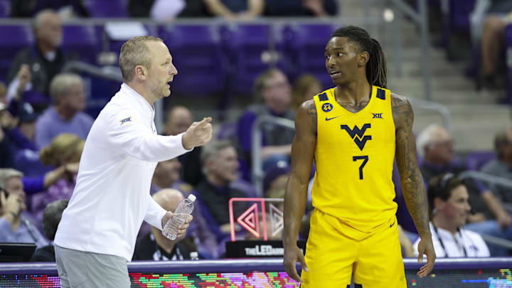 Feb 5, 2025; Fort Worth, Texas, USA; West Virginia Mountaineers guard Javon Small (7) speaks with West Virginia Mountaineers head coach Darian DeVries during the second half against the TCU Horned Frogs at Ed and Rae Schollmaier Arena. Mandatory Credit: Kevin Jairaj-Imagn Images Feb 5, 2025; Fort Worth, Texas, USA; West Virginia Mountaineers guard Javon Small (7) speaks with West Virginia Mountaineers head coach Darian DeVries during the second half against the TCU Horned Frogs at Ed and Rae Schollmaier Arena. Mandatory Credit: Kevin Jairaj-Imagn Images