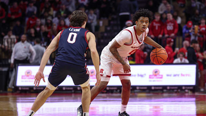 Dec 20, 2025; Piscataway, New Jersey, USA; Rutgers Scarlet Knights guard Tariq Francis (0) dribbles as Penn Quakers guard AJ Levine (0) defends during the second half at Jersey Mike's Arena. Mandatory Credit: Vincent Carchietta-Imagn Images