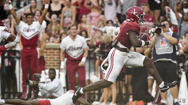 Aug 31, 2024; Tuscaloosa, Alabama, USA;  Alabama Crimson Tide wide receiver Kendrick Law (1) leaps past a Western Kentucky Hilltoppers defender on his way to a touchdown during the first half at Bryant-Denny Stadium.  Mandatory Credit: Gary Cosby Jr.-Imagn Images