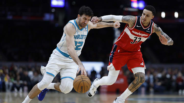 Mar 8, 2024; Washington, District of Columbia, USA; Charlotte Hornets guard Vasa Micic (22) drives to the basket as Washington Wizards forward Kyle Kuzma (33) defends in the second half at Capital One Arena. Mandatory Credit: Geoff Burke-Imagn Images
